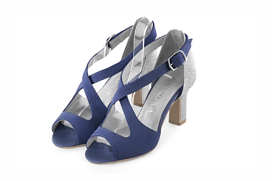 Prussian blue and silver elegant sandals with crossed straps across the instep, closed at the back. Round toe. High kitten heels.